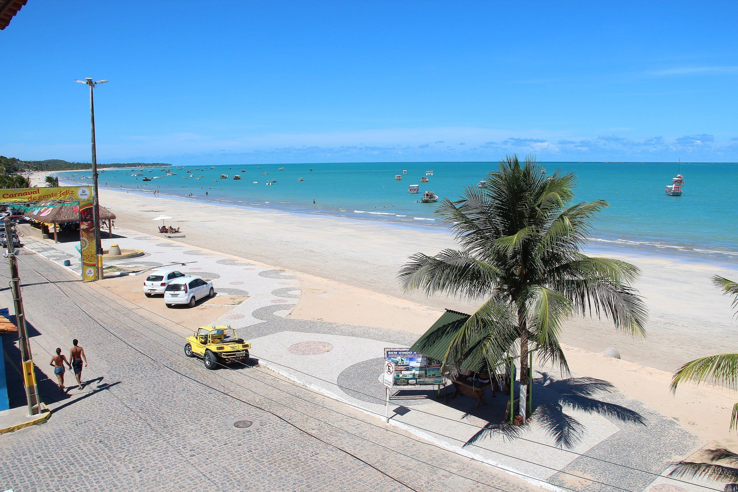 Orla de Maragogi vista do alto, com calçadão, coqueiro e mar verde-azulado